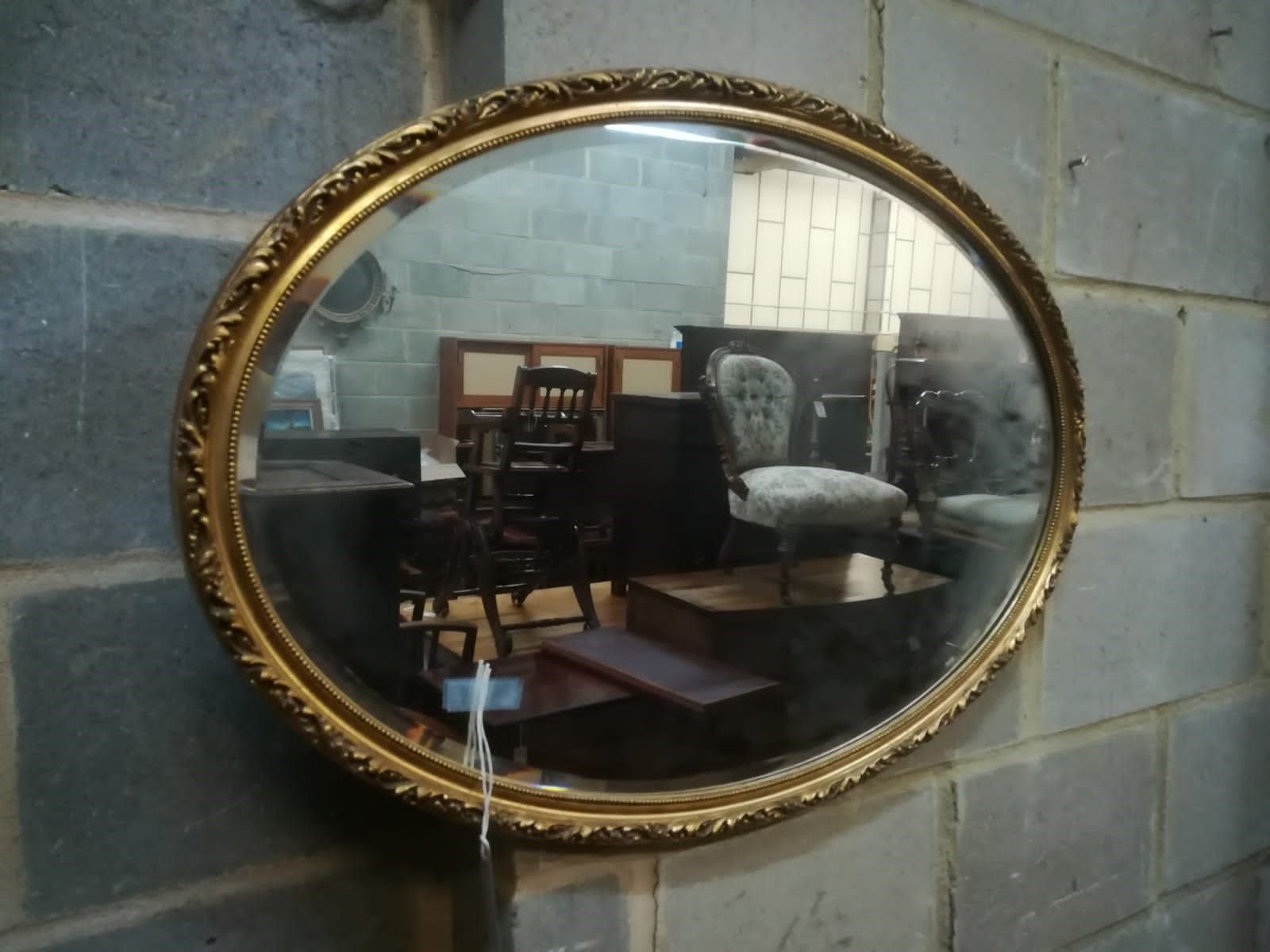 A gilt framed oval mirror, width 81cm, depth 3cm, height 56cm
